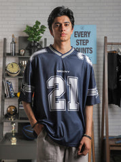 Male model facing camera in oversized navy GROOVY basketball jersey with large “21” and sleeve star graphics.