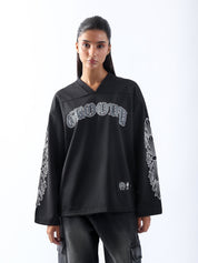 Female model wearing GROOVY’s Chrome Hearts black jersey, showing front and sleeve gothic graphics.