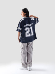 Female model looking over shoulder, showcasing back print of the All Stars Basketball Jersey with GROOVY logo and number 21.