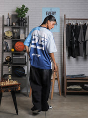 Back view of woman wearing oversized racing jersey with number 25 and Groovy Culture logo – indoor lifestyle streetwear shoot in Pakistan
