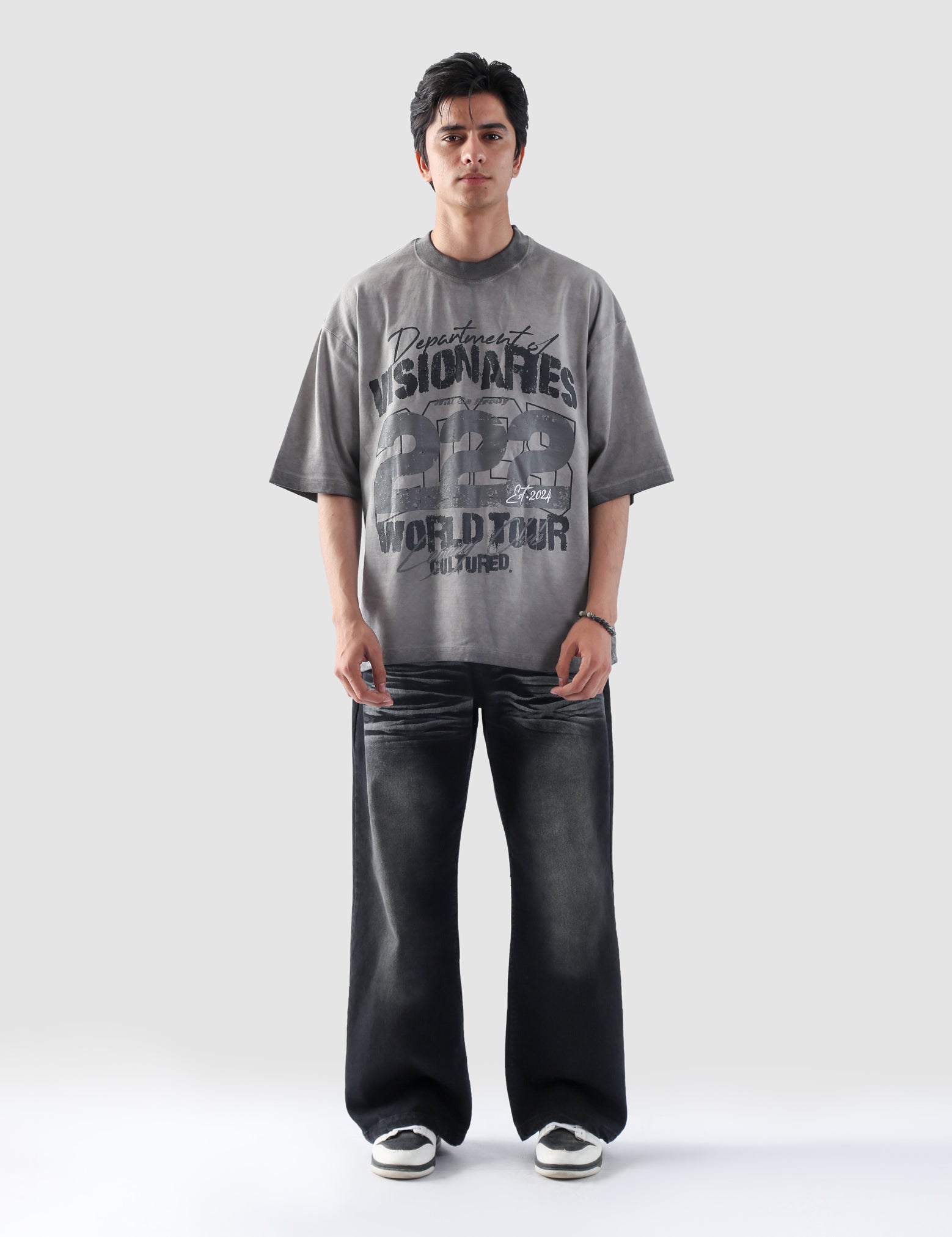 Model wearing Cultured’s Dept. of Visionaries oversized t-shirt in oil fade wash, front-facing full-body shot.