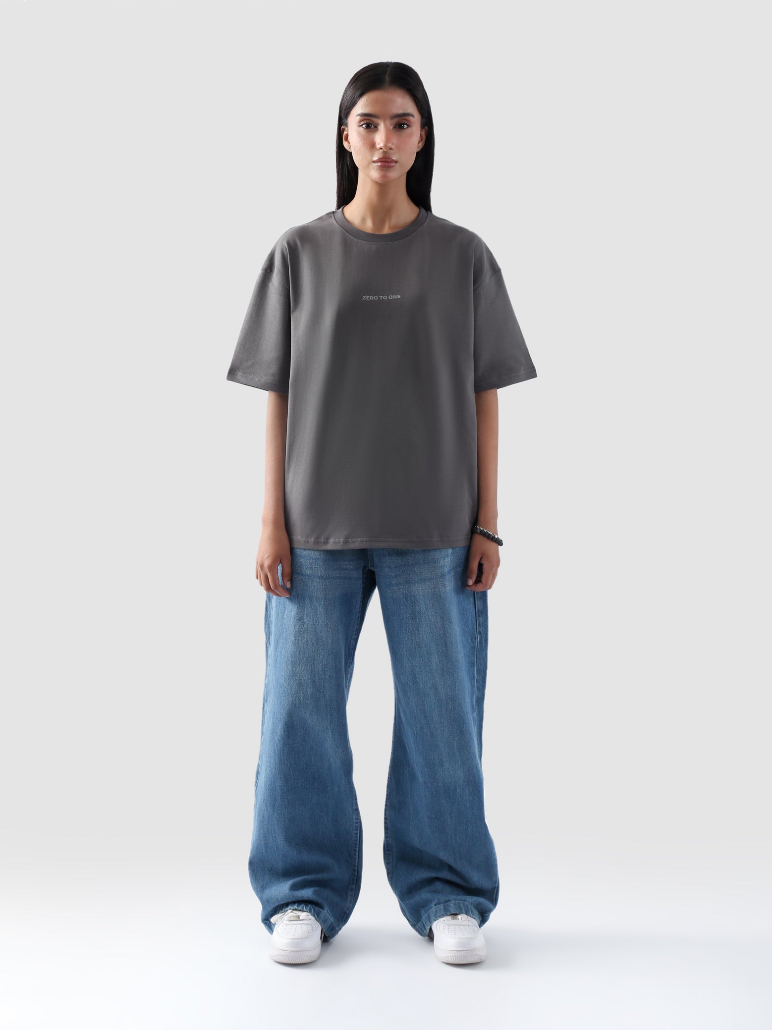Woman wearing grey oversized t-shirt with 'Zero to One' print – unisex streetwear in Pakistan by Groovy