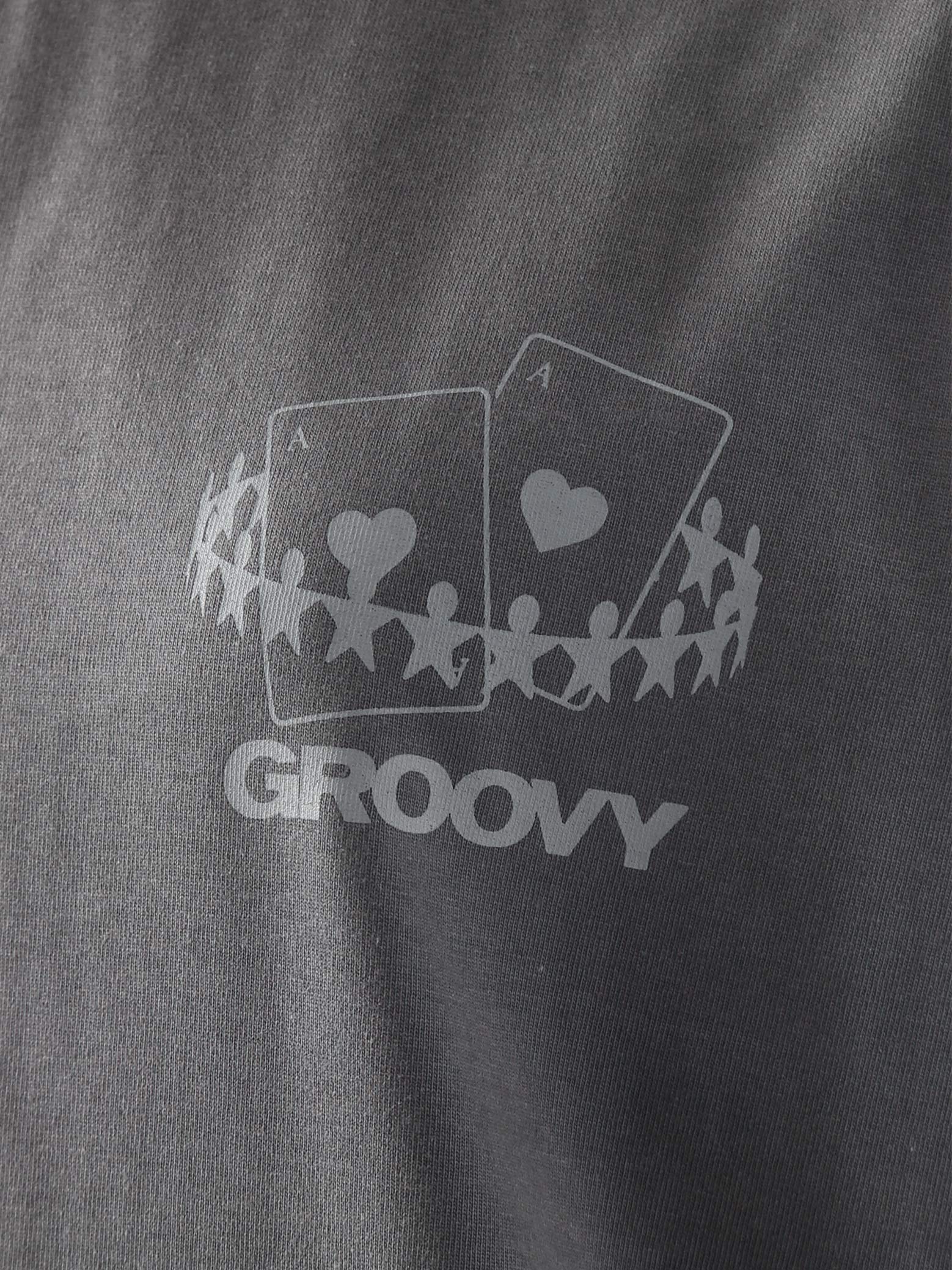 Male model wearing stone grey oversized t-shirt in Pakistan by Groovy – drop shoulder, baggy fit graphic tee styled with loose denim jeans