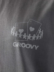 Male model wearing stone grey oversized t-shirt in Pakistan by Groovy – drop shoulder, baggy fit graphic tee styled with loose denim jeans