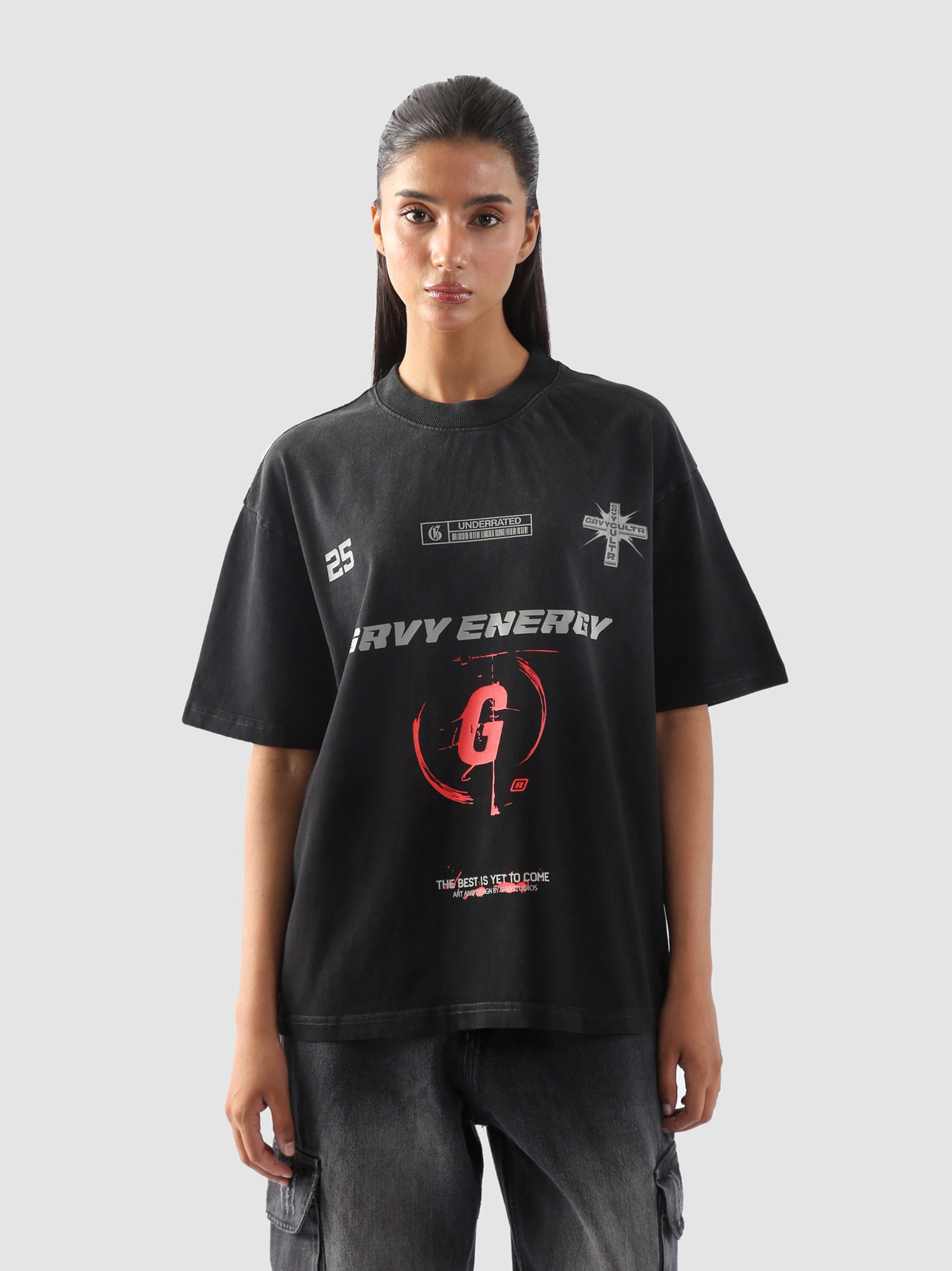 Close-up of "GROOVY Energy" t-shirt featuring silver and red graphic print and slogan “The Best is Yet to Come” – urban streetwear detail.