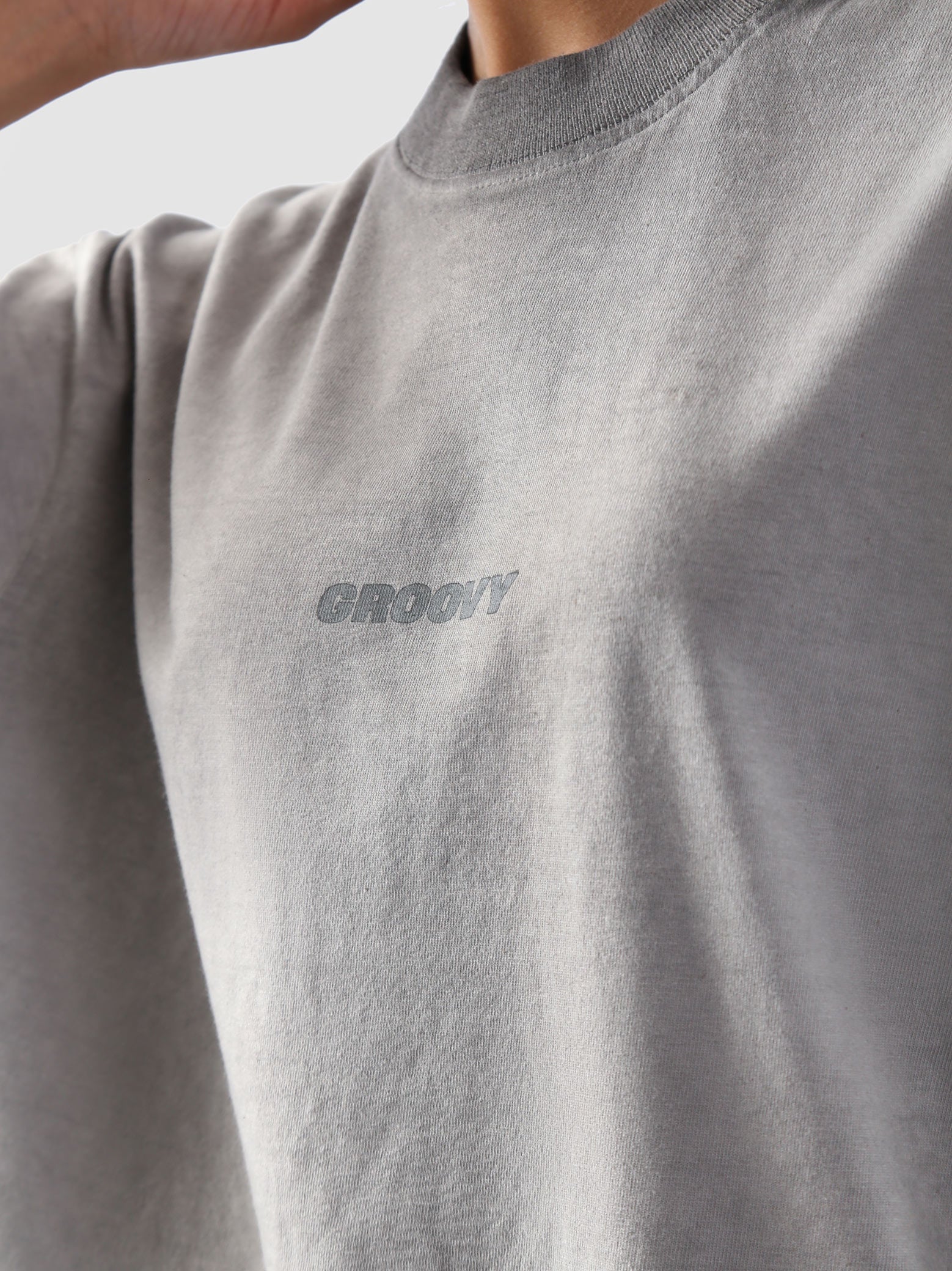Close-up of the Oil Fade Blank t-shirt showcasing GROOVY’s signature logo screen-printed on the chest and the garment’s unique textured oil-washed finish.
