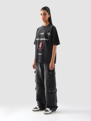 Side angle of female model showcasing the bold fit and statement design of the "GROOVY Energy" oversized t-shirt paired with street cargo pants.