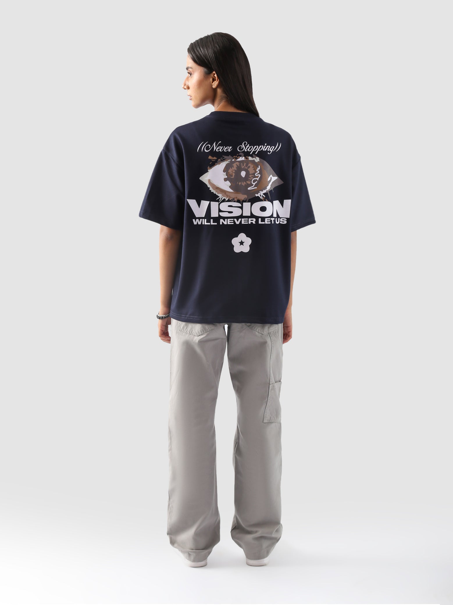 back view of a model wearing the "Never Stopping Culture" tee in navy blue. The oversized fit and front graphic featuring a bold star and "CLTR" text evoke a strong streetwear identity rooted in hustle and ambition.