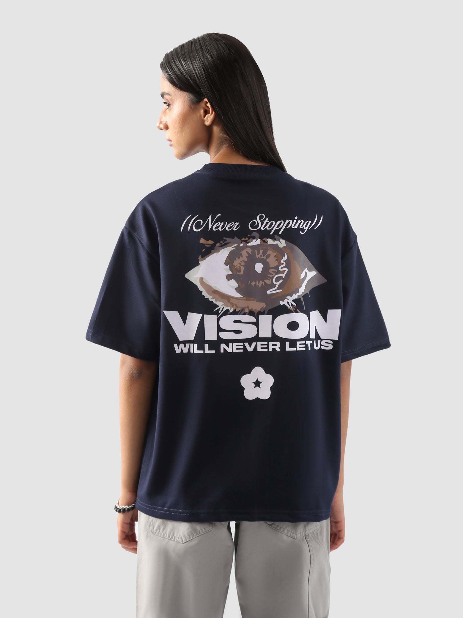 back view of a model wearing the "Never Stopping Culture" tee in navy blue. The oversized fit and front graphic featuring a bold star and "CLTR" text evoke a strong streetwear identity rooted in hustle and ambition.