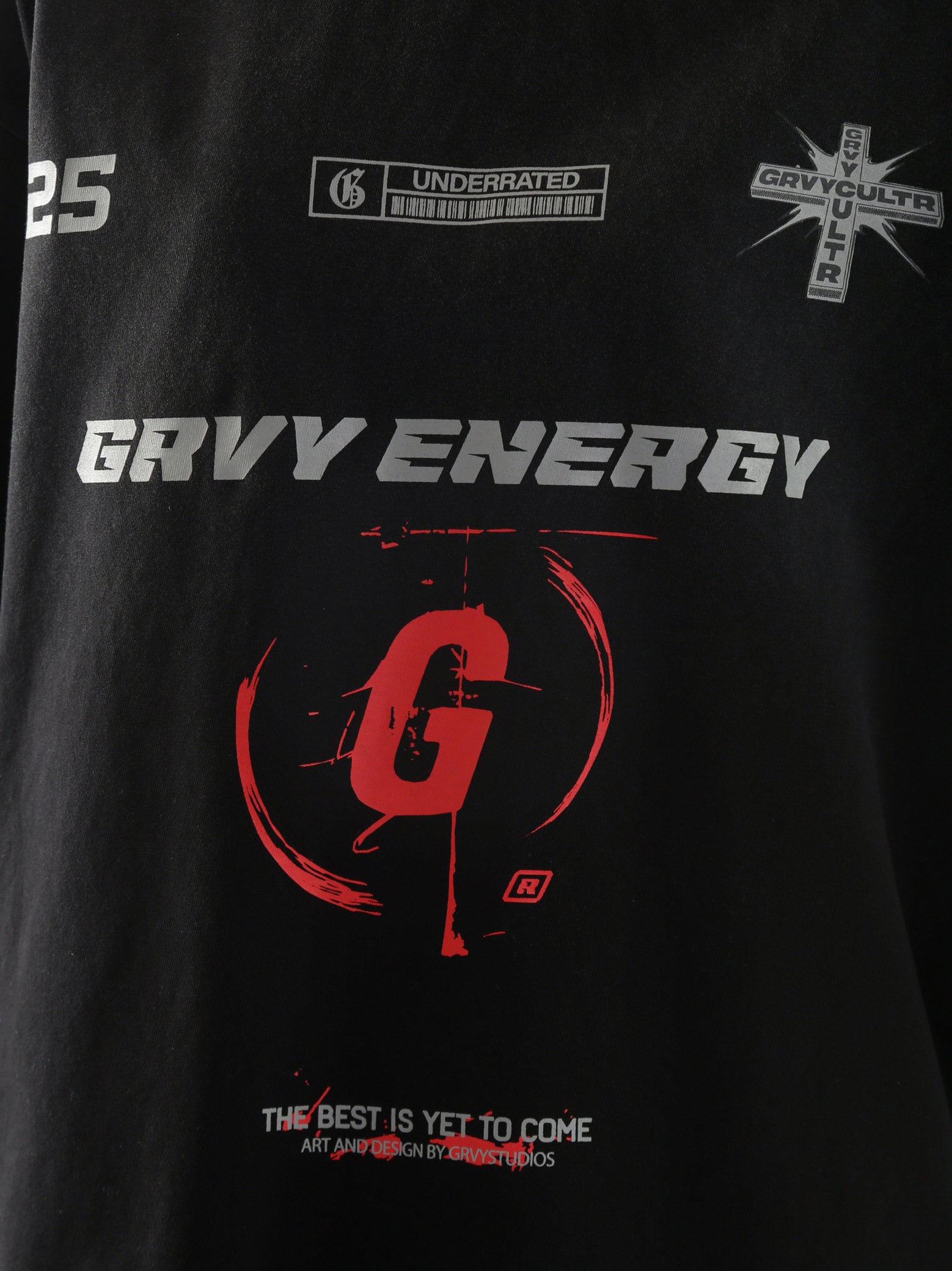 Close-up of "GROOVY Energy" t-shirt featuring silver and red graphic print and slogan “The Best is Yet to Come” – urban streetwear detail.