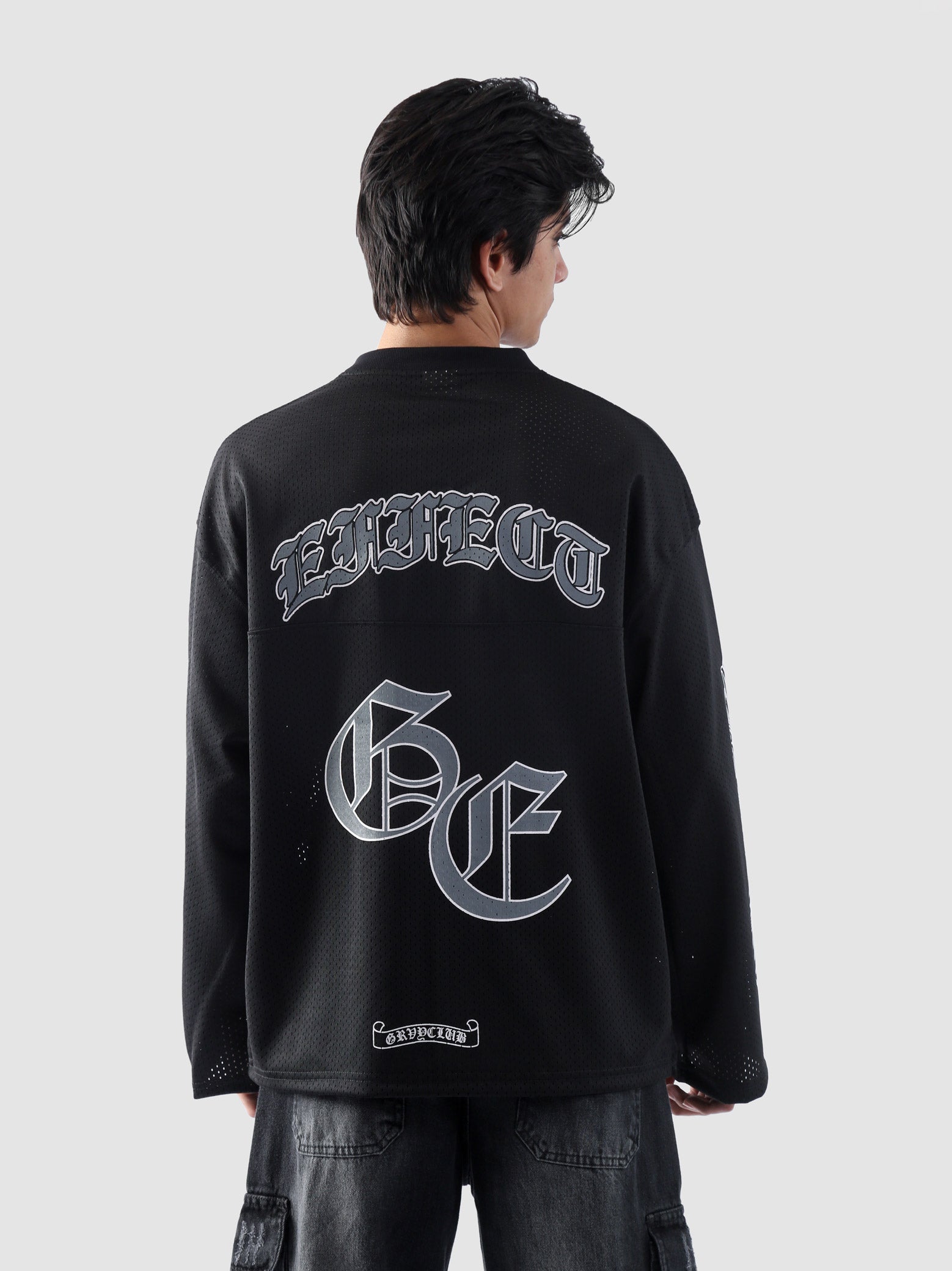 Close-up of the back gothic print text 'EFFECT' and large stylized GE lettering on GROOVY's mesh jersey.