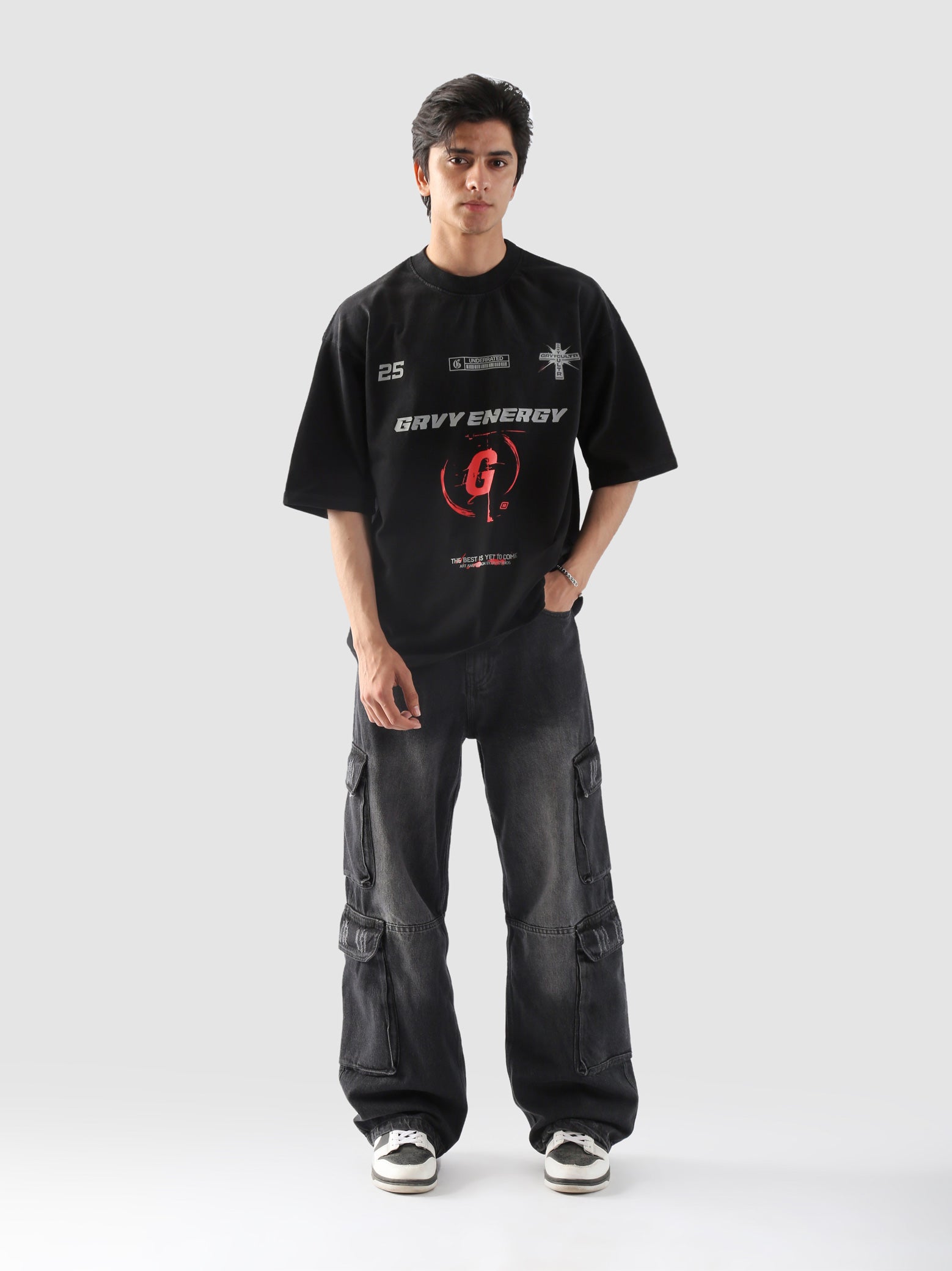Male model posing in "GROOVY Energy" oversized t-shirt and washed black cargo pants – unisex streetwear t-shirt in Pakistan.
