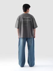 Back view of man wearing grey oversized t-shirt with 'Humble Beginnings' text – baggy streetwear tee by Groovy Pakistan
