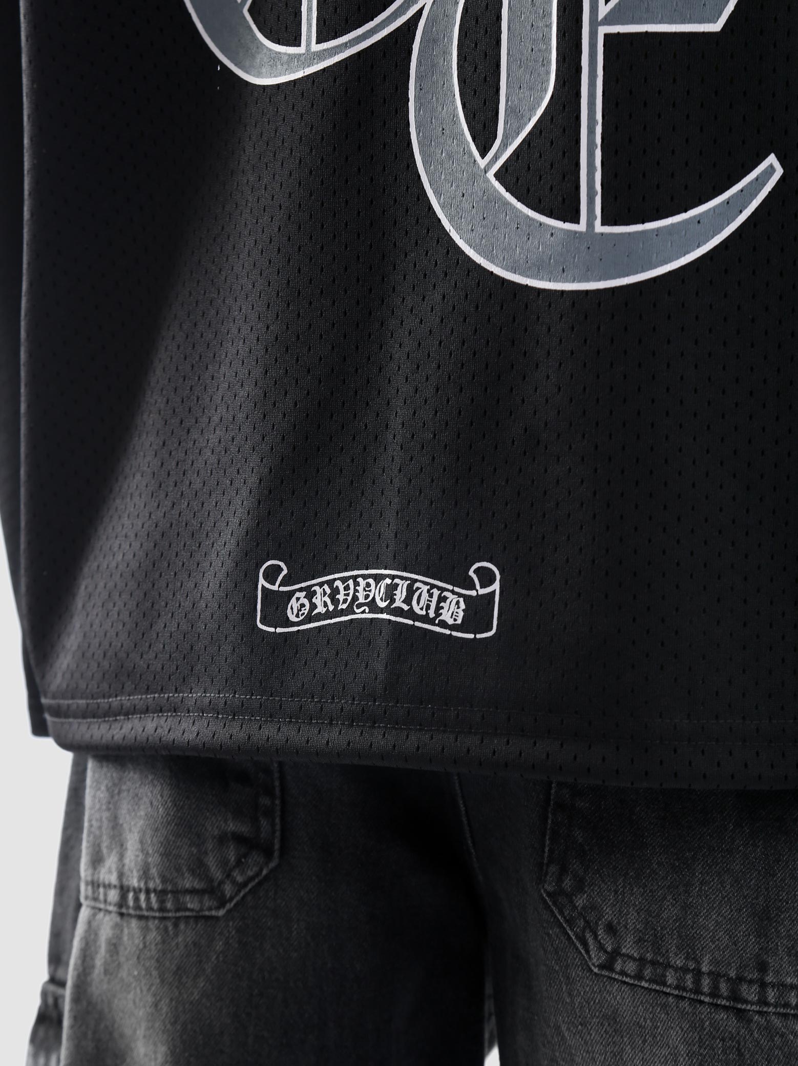 Back lower hem detail of GROOVY's Chrome Hearts jersey showcasing GRVYCLUB label design.