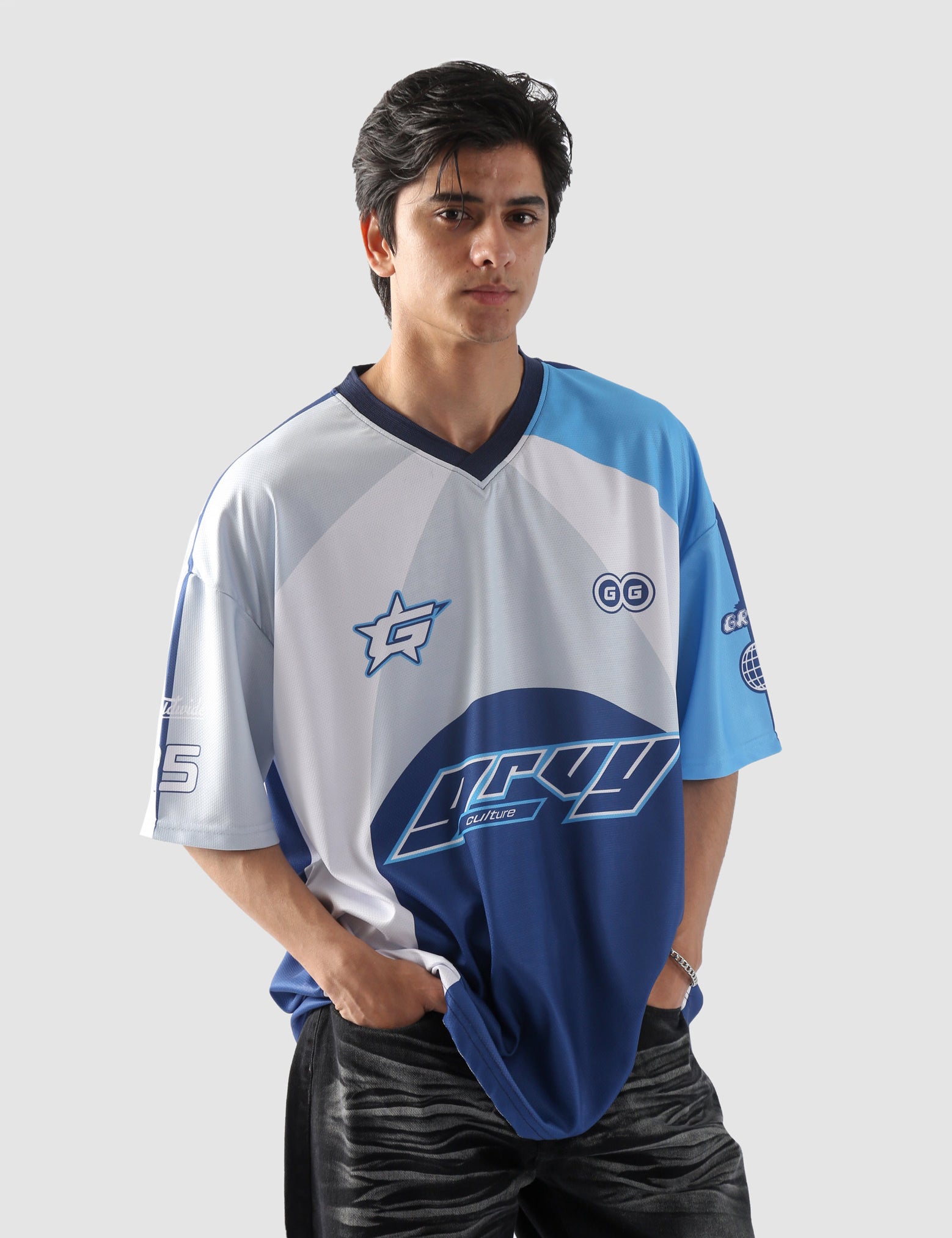 Man wearing oversized blue and white sublimation jersey with racing-inspired graphics – streetwear top by Groovy Culture Pakistan