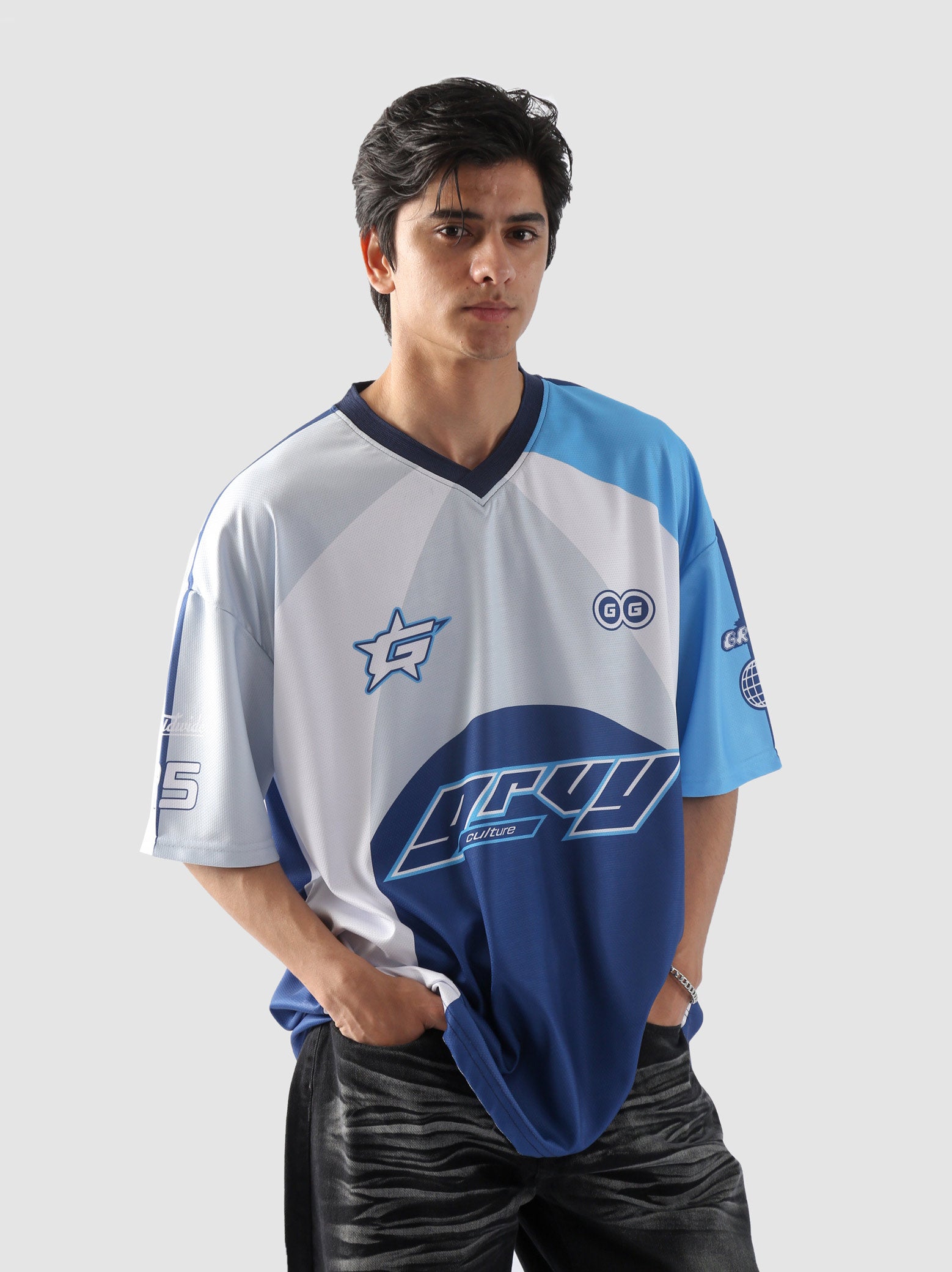 Man wearing oversized blue and white sublimation jersey with racing-inspired graphics – streetwear top by Groovy Culture Pakistan