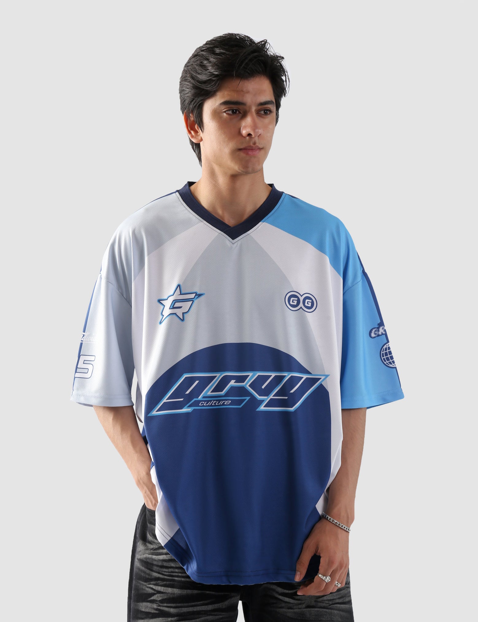 Man wearing oversized blue and white sublimation jersey with racing-inspired graphics – streetwear top by Groovy Culture Pakistan