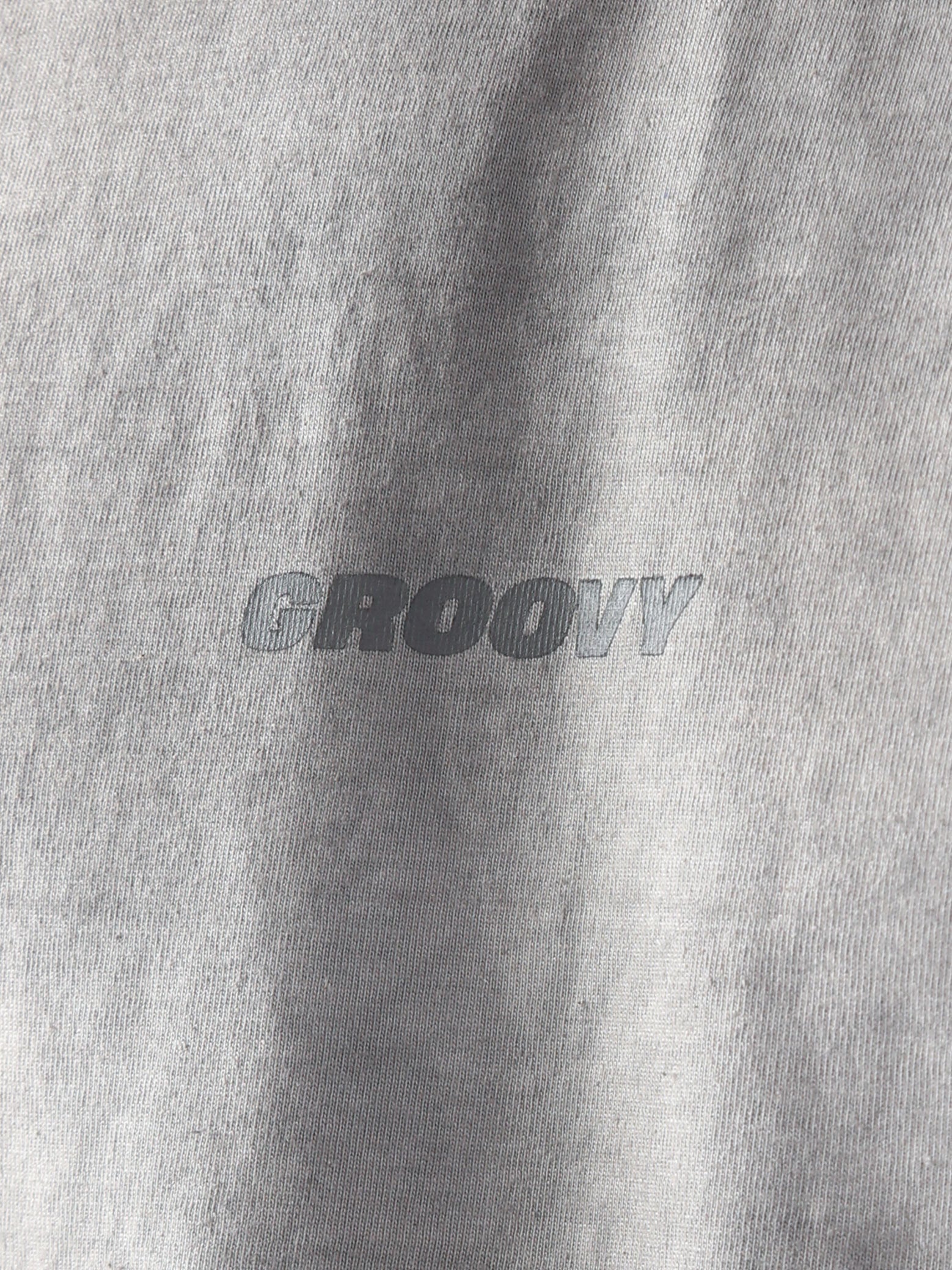Close-up of the Oil Fade Blank t-shirt showcasing GROOVY’s signature logo screen-printed on the chest and the garment’s unique textured oil-washed finish.
