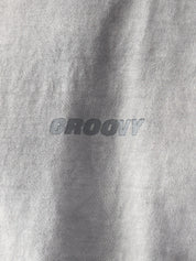 Close-up of the Oil Fade Blank t-shirt showcasing GROOVY’s signature logo screen-printed on the chest and the garment’s unique textured oil-washed finish.

