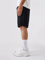 Black Aim Shorts on model, relaxed-fit men's gym and casual shorts by GROOVY Pakistan