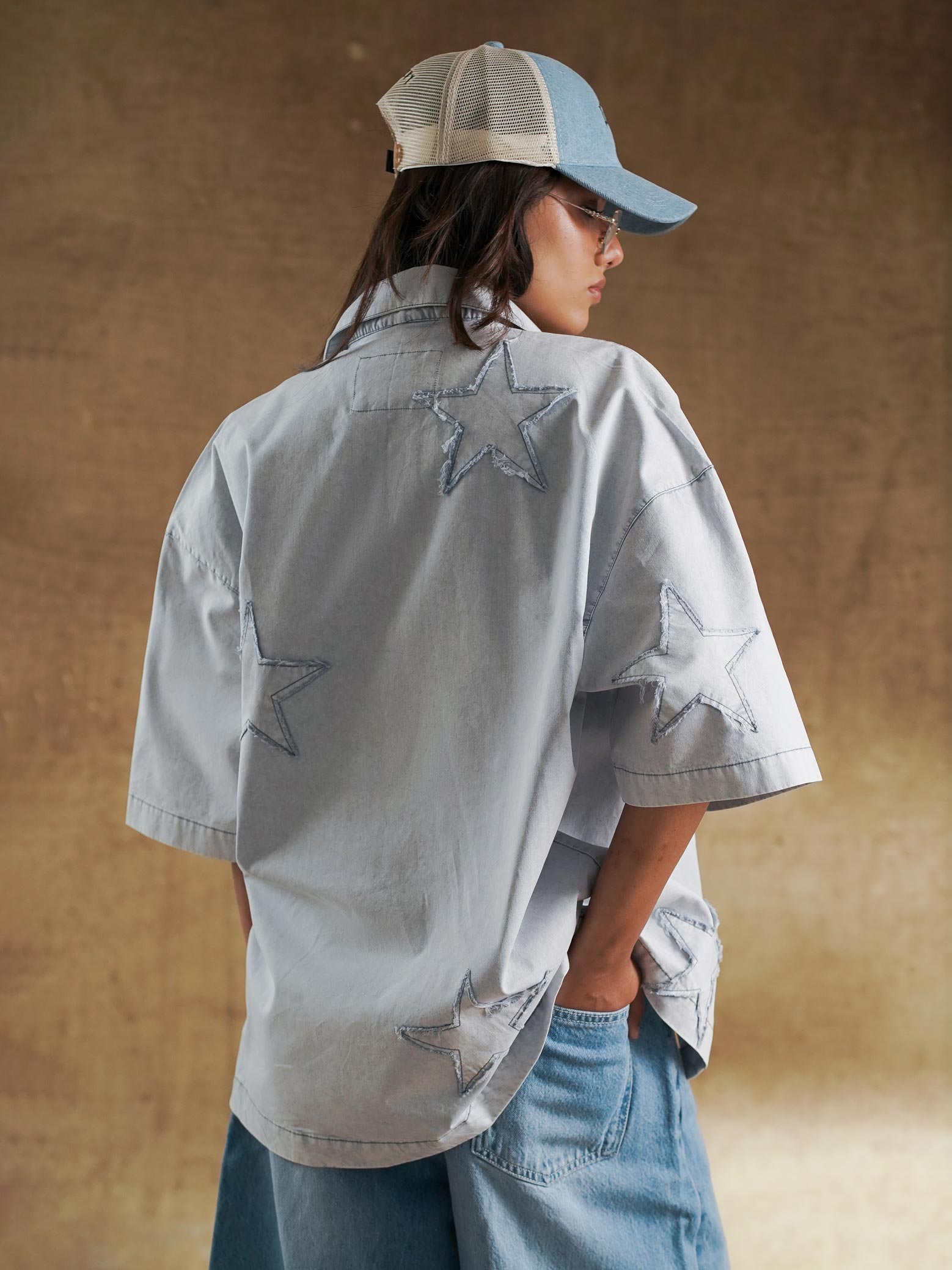 Reverse appliqué stars across the back of a grey denim shirt - GROOVY Pakistan